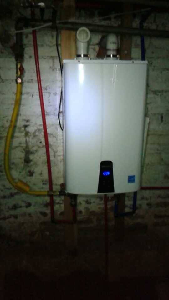 Tankless water heater mounted on a basement wall
