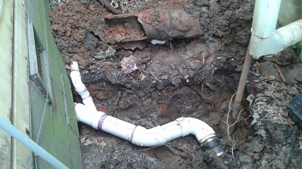 Excavated trench with new white PVC drain pipe installed by Local Plumbing & Sewer